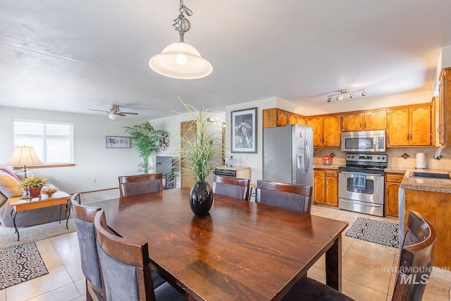 dining room with a textured ceiling, ceiling fan, and light tile patterned flooring