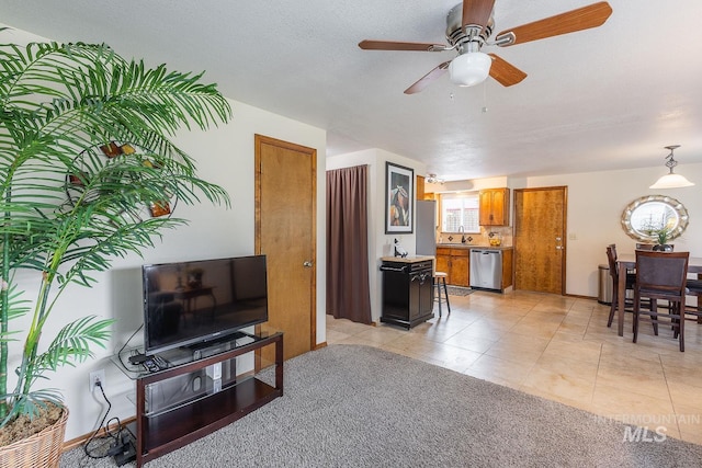 living area featuring light tile patterned flooring, ceiling fan, and baseboards