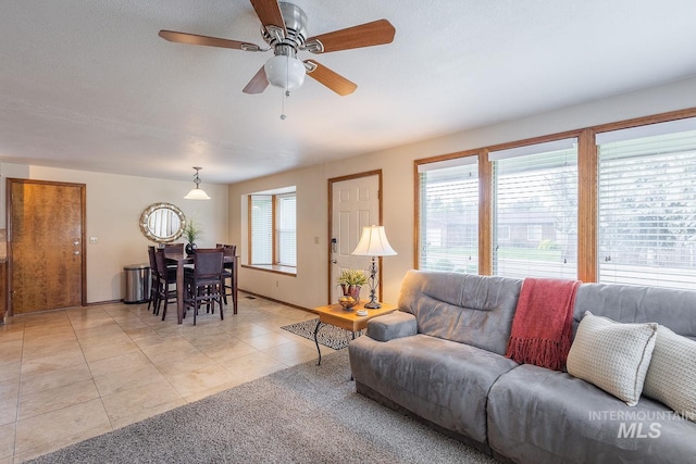 living area featuring light tile patterned floors and a ceiling fan