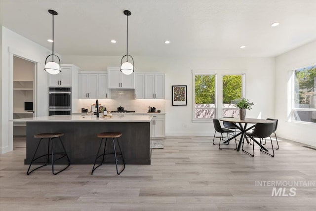 2391 E Snocreek Dr, Eagle, ID 83616 - kitchen featuring light countertops, white cabinets, recessed lighting, and tasteful backsplash