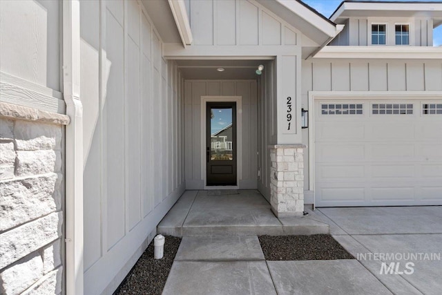 2391 E Snocreek Dr, Eagle, ID 83616 - property entrance featuring a garage, board and batten siding, and stone siding