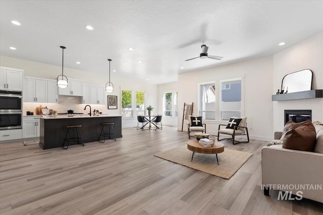 2391 E Snocreek Dr, Eagle, ID 83616 - living room featuring recessed lighting, a ceiling fan, light wood finished floors, and a fireplace