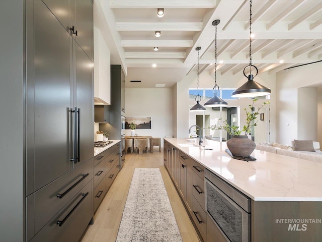 6241 W Strant St, Eagle, ID 83616 - kitchen featuring stainless steel appliances, beamed ceiling, a sink, a spacious island, and light wood finished floors