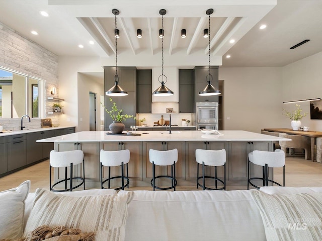6241 W Strant St, Eagle, ID 83616 - kitchen featuring gray cabinets, stainless steel double oven, tasteful backsplash, light countertops, and a breakfast bar area