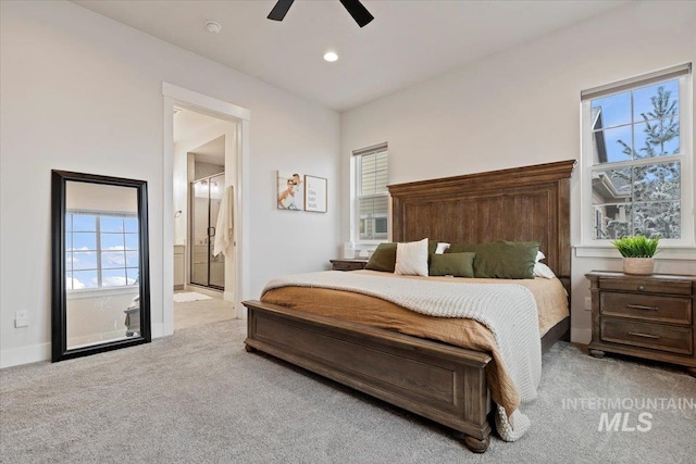 bedroom with ceiling fan, light carpet, and ensuite bath