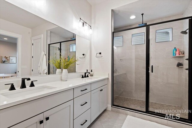 bathroom with a shower with door and vanity