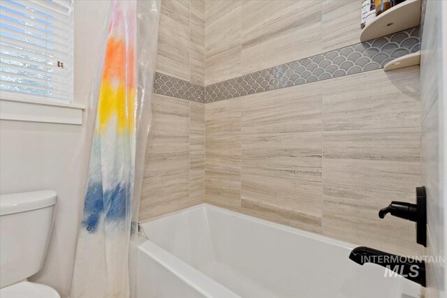 bathroom featuring toilet and shower / bath combo with shower curtain