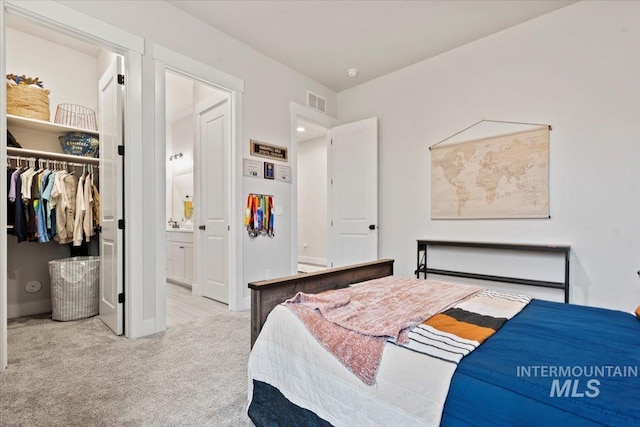 carpeted bedroom featuring ensuite bath and a closet