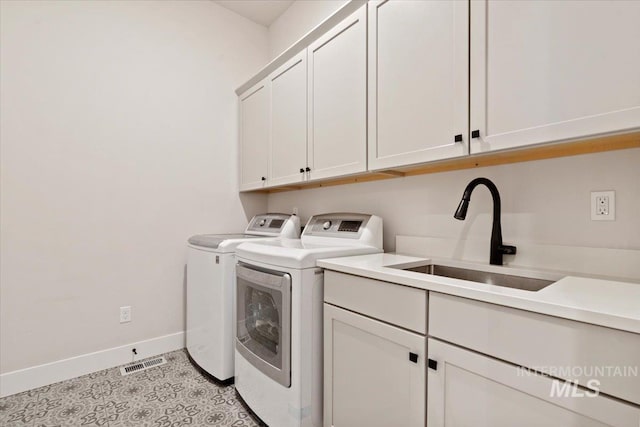 laundry room featuring cabinets, washing machine and dryer, light tile patterned flooring, and sink