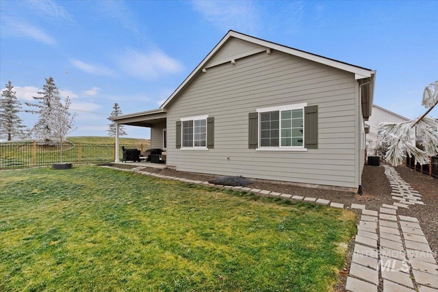 view of side of home with a yard and a patio area