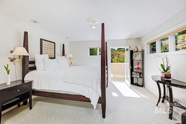 carpeted bedroom with multiple windows and access to exterior