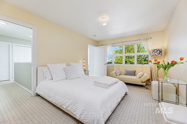bedroom with light colored carpet and baseboards