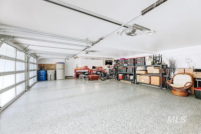 garage with freestanding refrigerator and a garage door opener