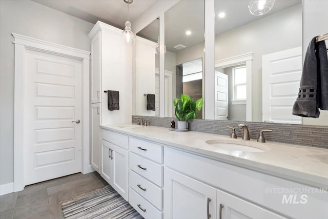 bathroom featuring double vanity, decorative backsplash, a sink, and recessed lighting