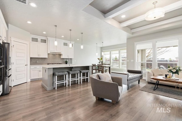 living room featuring beamed ceiling, wood finished floors, and recessed lighting