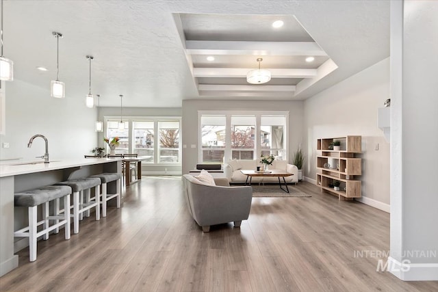 living area with baseboards, a tray ceiling, wood finished floors, and recessed lighting