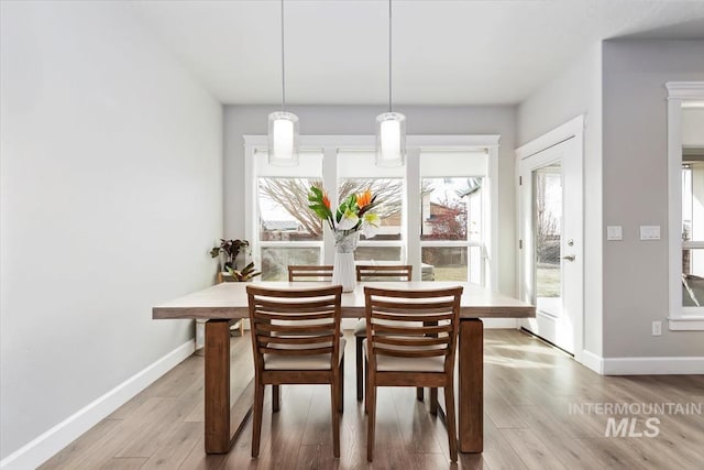 dining space featuring wood finished floors and baseboards