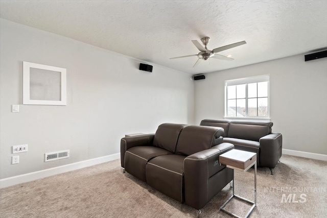 carpeted living room featuring ceiling fan, a textured ceiling, visible vents, and baseboards