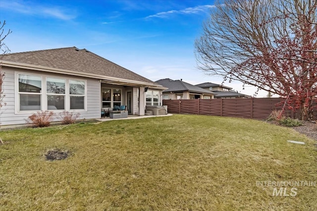 back of property featuring a yard, a shingled roof, a patio area, a fenced backyard, and an outdoor living space