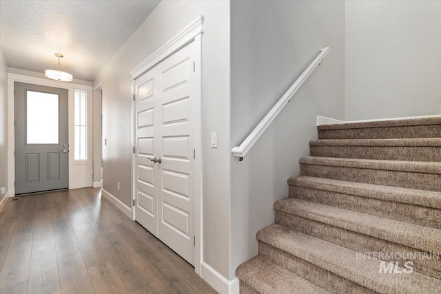 entrance foyer with hardwood / wood-style flooring, stairs, and baseboards