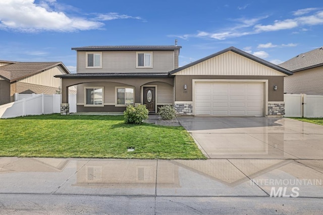 traditional-style home with driveway, a front yard, fence, and a garage