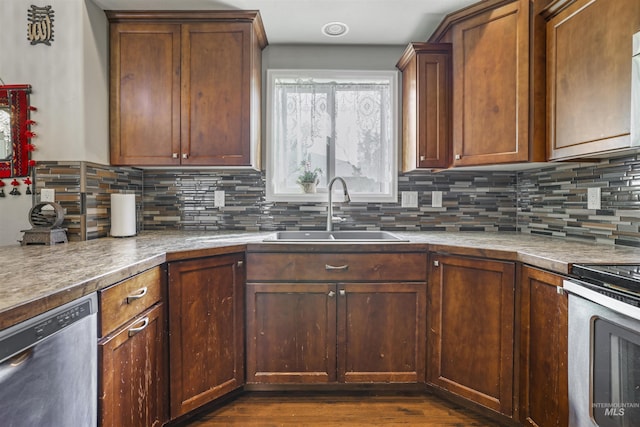 kitchen featuring a sink, stainless steel appliances, dark wood-type flooring, and decorative backsplash