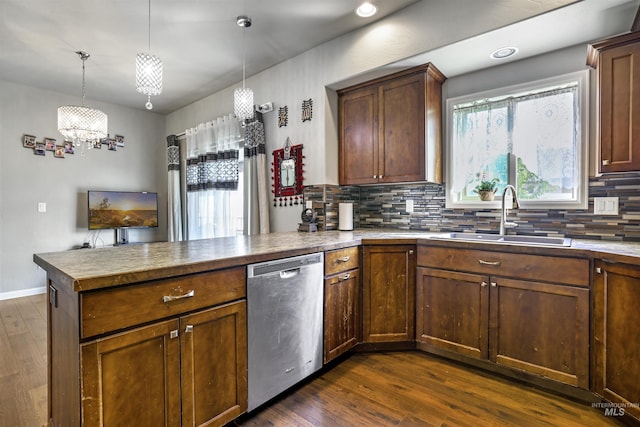 kitchen featuring dark wood-type flooring, a chandelier, a sink, dishwasher, and a peninsula