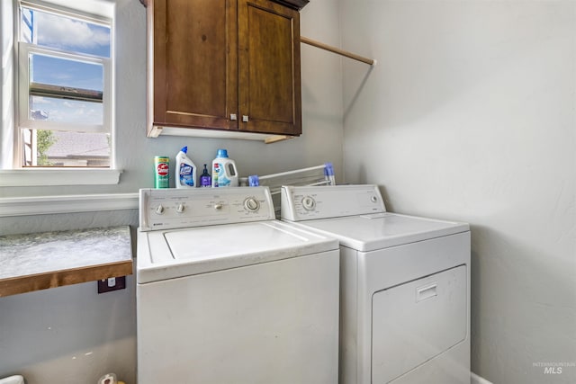 washroom with separate washer and dryer and cabinet space