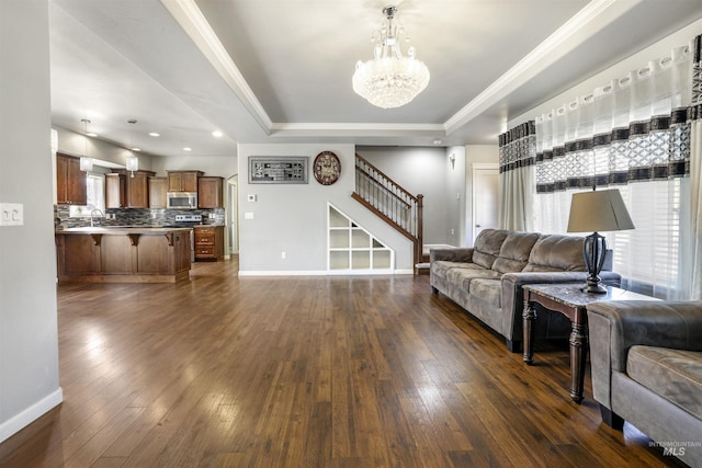 living room with stairs, dark wood-style floors, a chandelier, and a raised ceiling