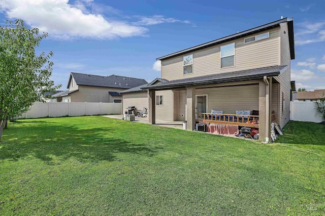 rear view of property featuring a fenced backyard, a yard, and a patio area