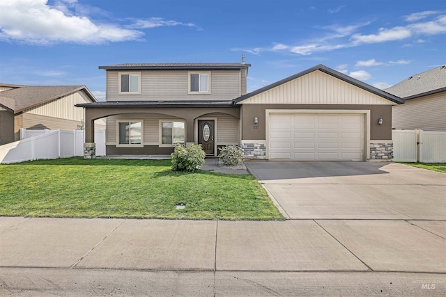 traditional-style home with concrete driveway, fence, an attached garage, stone siding, and a front yard