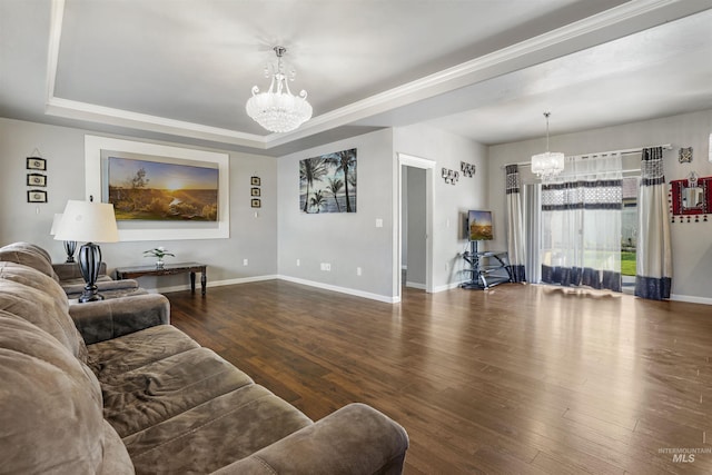 living area with a tray ceiling, baseboards, wood finished floors, and a chandelier