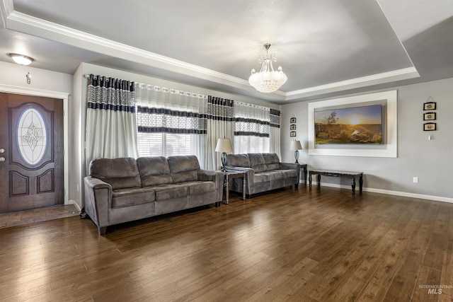 living room with baseboards, a tray ceiling, an inviting chandelier, and dark wood finished floors