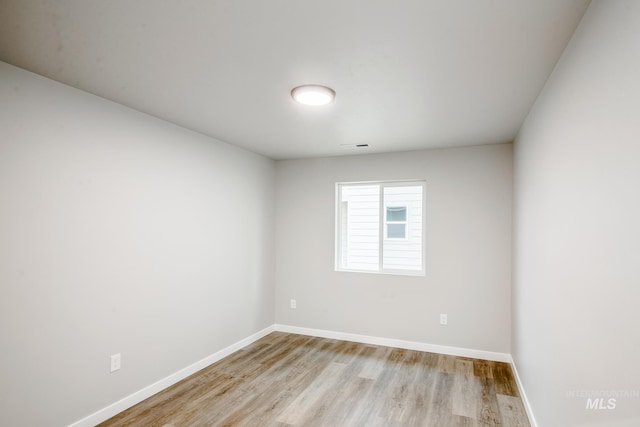 empty room featuring wood finished floors and baseboards