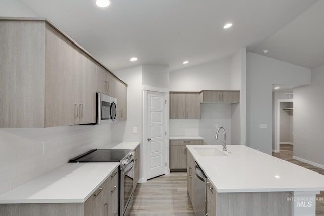 kitchen with lofted ceiling, light wood-style flooring, a sink, appliances with stainless steel finishes, and modern cabinets