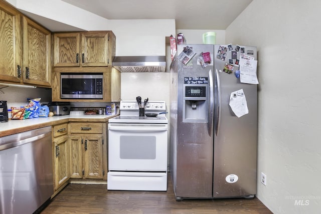 kitchen featuring stainless steel appliances, light countertops, dark wood-style flooring, and wall chimney range hood