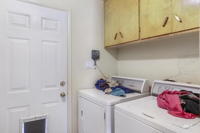 laundry room with washing machine and clothes dryer and cabinet space