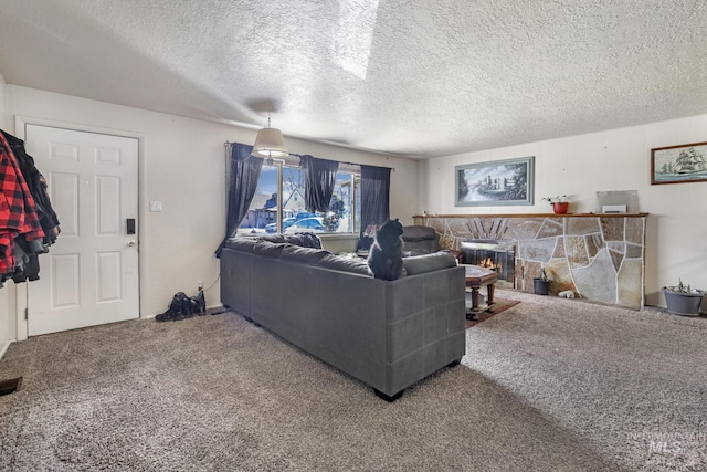 carpeted living area with a textured ceiling and a stone fireplace