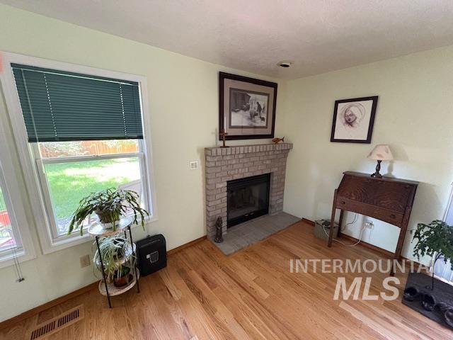 3707 N Jullion Way, Boise, ID 83704 - living area with wood finished floors and a brick fireplace