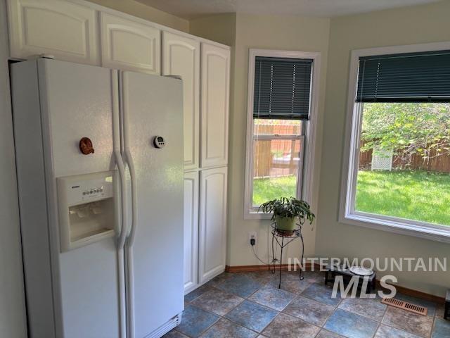 3707 N Jullion Way, Boise, ID 83704 - kitchen with white fridge with ice dispenser, white cabinetry, and plenty of natural light
