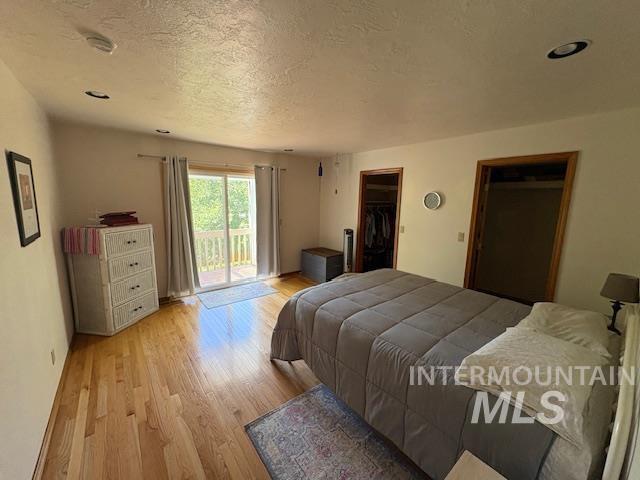 3707 N Jullion Way, Boise, ID 83704 - bedroom with light wood-style flooring, access to outside, a textured ceiling, a spacious closet, and recessed lighting