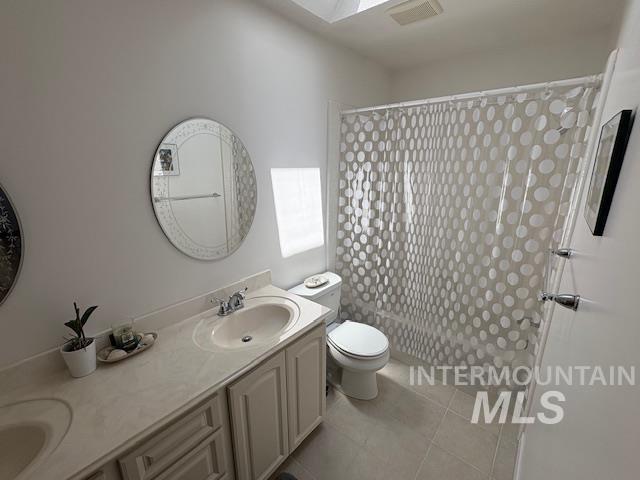 3707 N Jullion Way, Boise, ID 83704 - full bathroom with toilet, double vanity, a shower with curtain, and tile patterned floors