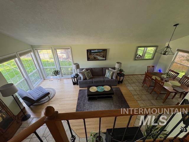 3707 N Jullion Way, Boise, ID 83704 - living room featuring healthy amount of natural light, wood finished floors, lofted ceiling, and a textured ceiling