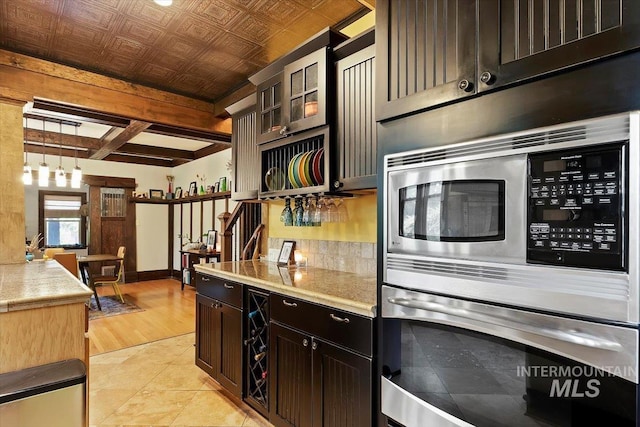 204 7th Ave N, Twin Falls, ID 83301 - kitchen featuring appliances with stainless steel finishes, light countertops, light tile patterned floors, hanging light fixtures, and glass insert cabinets