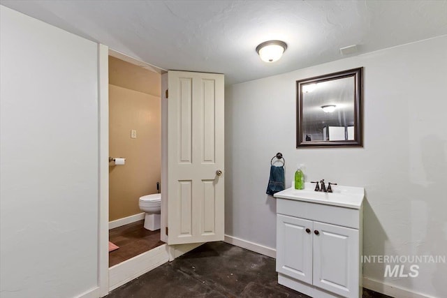 204 7th Ave N, Twin Falls, ID 83301 - bathroom featuring vanity, toilet, concrete floors, and baseboards