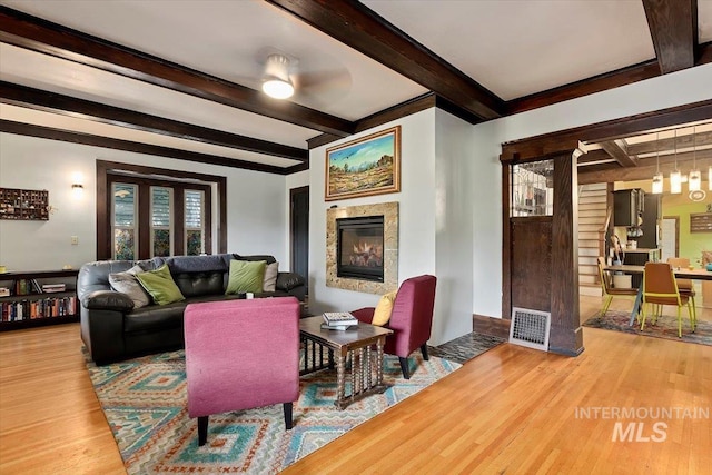 204 7th Ave N, Twin Falls, ID 83301 - living area with wood finished floors, beamed ceiling, a glass covered fireplace, and plenty of natural light