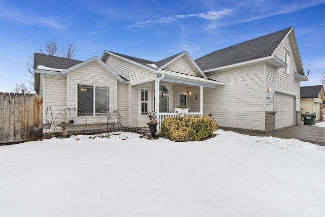 ranch-style house featuring a garage, covered porch, and fence