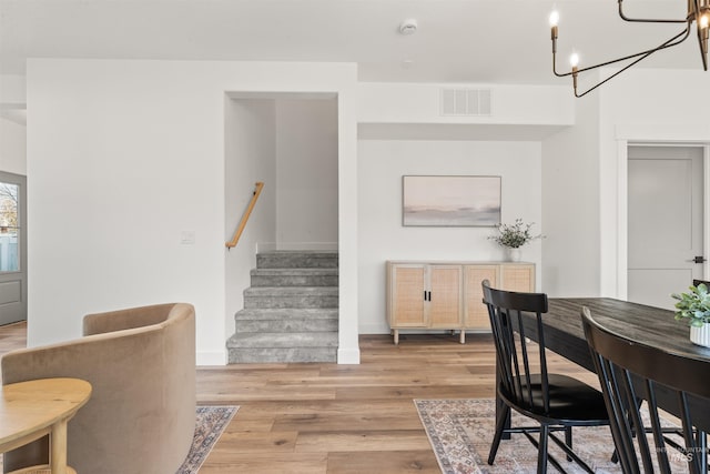 dining space featuring a notable chandelier and light wood-type flooring