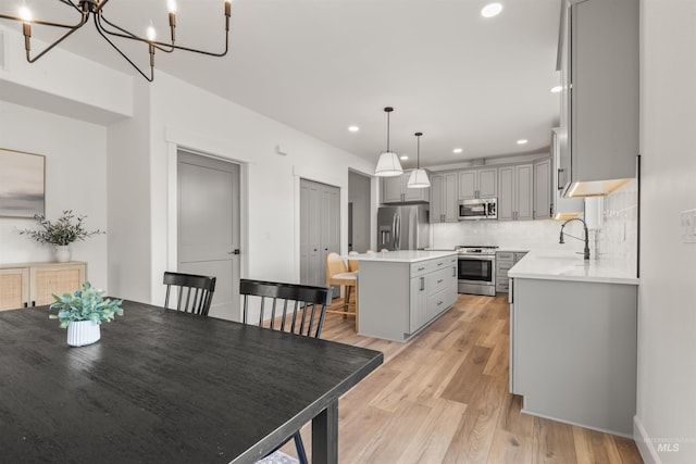 dining room with a chandelier, sink, and light hardwood / wood-style flooring