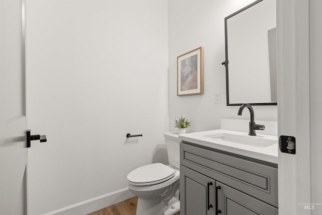 bathroom featuring hardwood / wood-style floors, vanity, and toilet